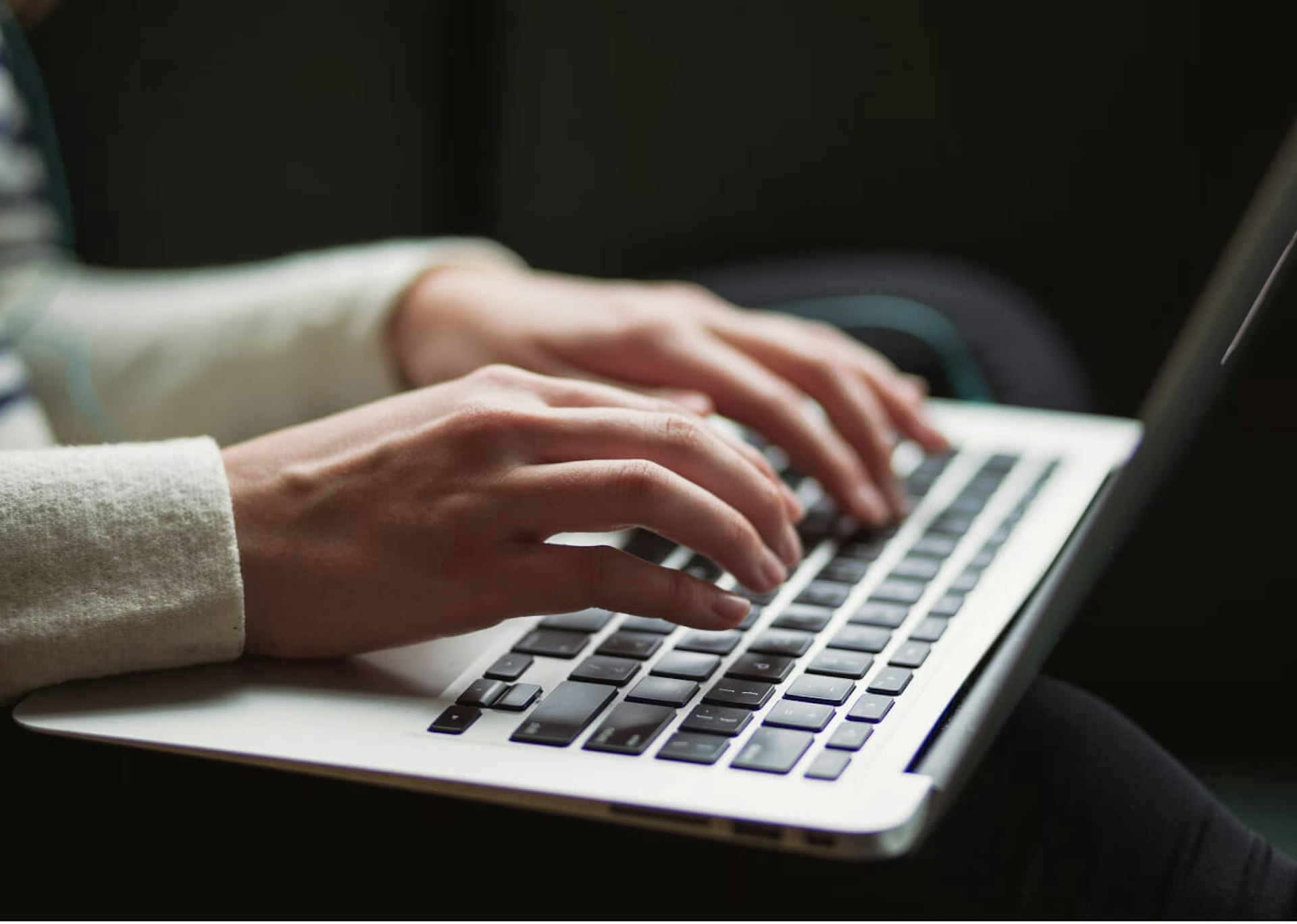 Hands typing on a laptop keyboard.